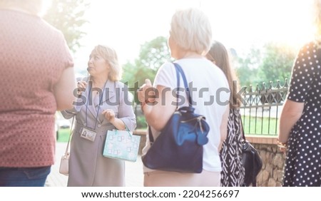 female guide is telling a group of tourists about something. Royalty-Free Stock Photo #2204256697