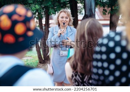 female guide is telling a group of tourists about something. Royalty-Free Stock Photo #2204256701