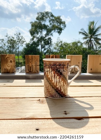 A cup with batik pictures