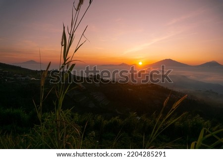 Beautiful golden sunrise over mountain range with view of vegetable plantation on the foreground