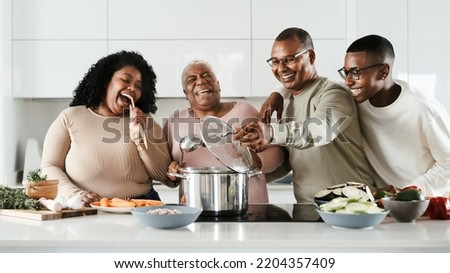 Happy Hispanic family having fun cooking together in modern kitchen - Food and parents unity concept Royalty-Free Stock Photo #2204357409