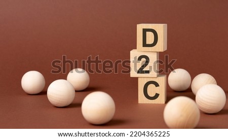 D2C - Direct to Consumer - letter pices on the wooden cubes, brown background.