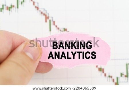 Business and trading concept. Against the background of the quote chart, a man holds a sign with the inscription - Banking analytics