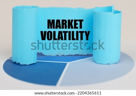 Business concept. On the blue diagram is a twisted paper sign with the inscription - Market Volatility