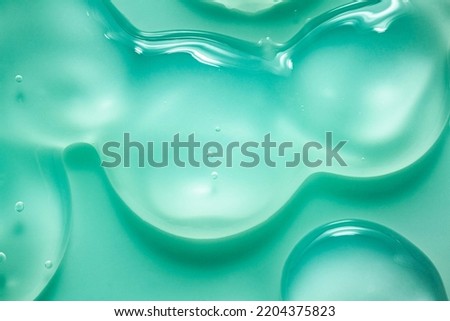 Cosmetic blue green gel or lotion or hyaluronic acid transparent gel drops texture background