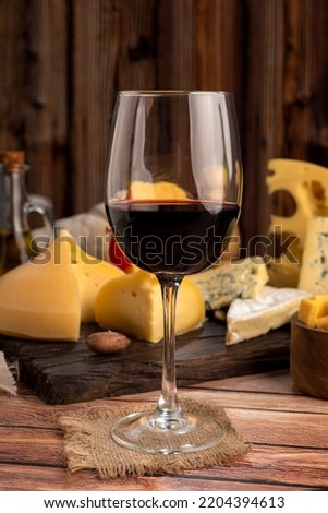 Red wine cup with varieties of oil and pepper background cheese and red wine bottle