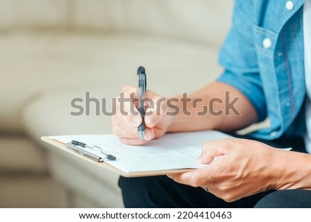 Male patient filling out a medical questionnaire Royalty-Free Stock Photo #2204410463