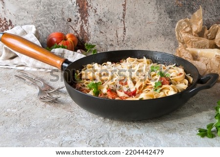 pan with pasta with tomato sauce, sardines and parmesan on the table Royalty-Free Stock Photo #2204442479