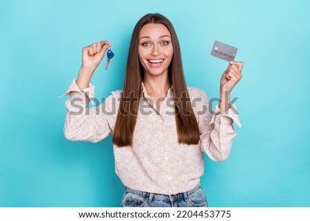 Photo of hooray young woman hold keys card yell wear white shirt isolated on blue color background