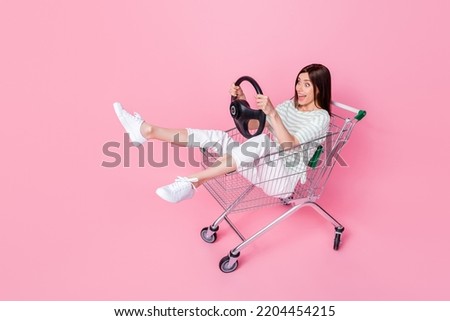 Full length photo of crazy funky lady customer buyer buy sit trolley dream imagine new car look empty space isolated pink color background