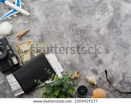 Preparing for vacation, vacation, air travel. Seashells, money, documents, tickets, a small airplane on a gray background. There are no people in the photo. There is free space to insert.