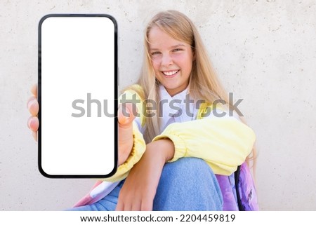 Teenage girl showing empty screen of mobile phone