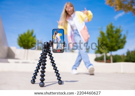 Teenage girl filming video of herself on mobile phone Royalty-Free Stock Photo #2204460627