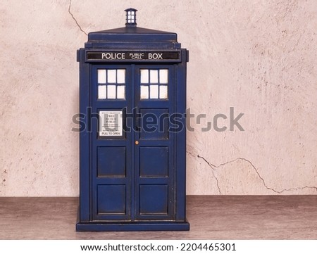 Police call box isolated on wall background. Tardis from Doctor Who. Top view with copy space for your text. Royalty-Free Stock Photo #2204465301