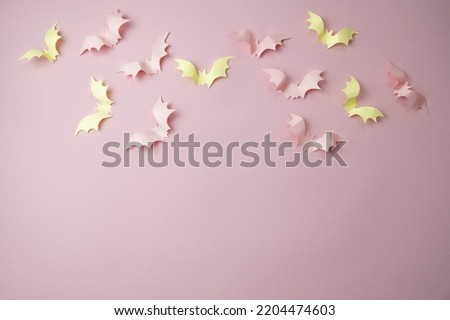 small light pink bats on a pink background with a place for text, the concept of a creative happy Halloween