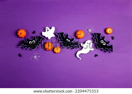 Halloween composition with cute bats, ghosts, pumpkins, spiders on purple background. Happy halloween banner mockup. Flat lay, top view, copy space.