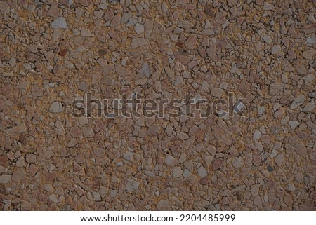 Grunge small dolomite crushed stone texture. Natural brown and beige colors stone background. High resolution seamless stone backdrop. Copy space for design and text.