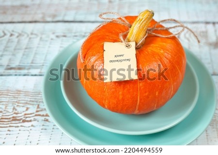 pumpkin with a tag on a blue plate close-up