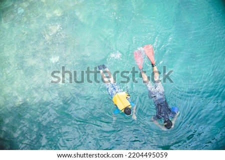 Miyakojima Island, a remote island in Okinawa Prefecture. Pictures of a parent and child swimming in a beautiful cove. Royalty-Free Stock Photo #2204495059