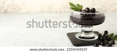 Dessert bowl of delicious black currant jam on light background with space for text