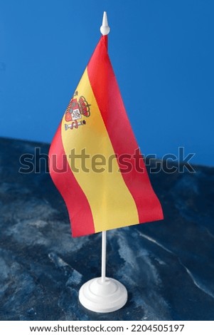 Flag of Spain on table against blue background