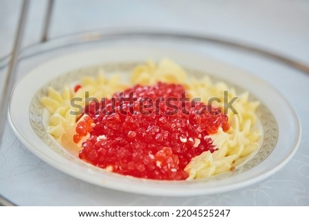 Red salmon caviar lies in a beautiful dish. Beautiful serving of food in a restaurant.