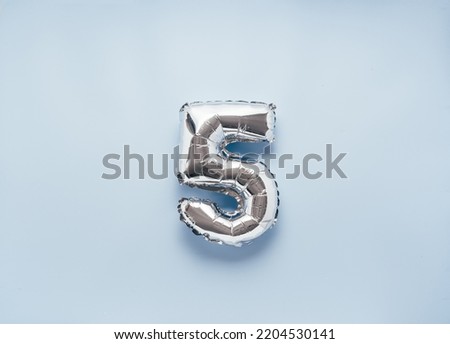 Silber balloon number 5 on light blue background for your New Year of birthday desing