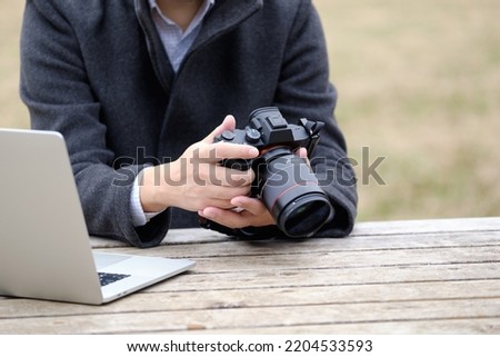 Male photographer operating a camera outdoors