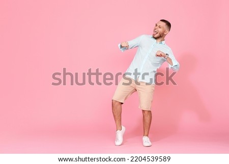 handsome smiling man in blue shirt dancing
