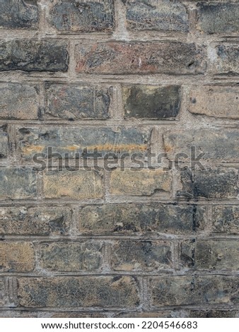 Old grey dark bricks held with cement