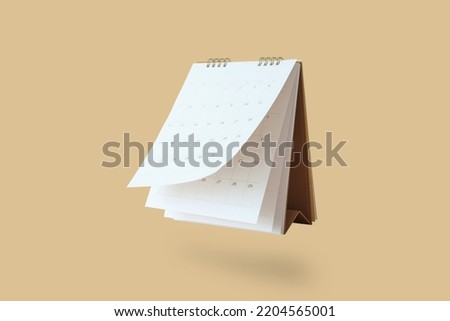 White paper desk calendar flipping page mockup isolated on brown background Royalty-Free Stock Photo #2204565001