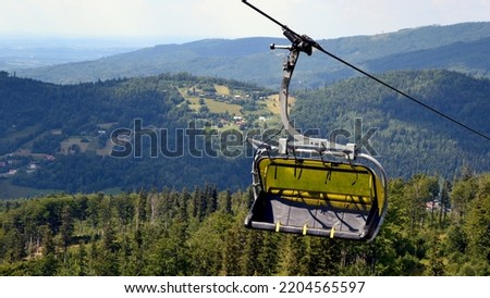 Mountain chairlift. 4-seater chairlift. The ski lift going to the station. Close up of an empty four person chair lift hanging at a ski lift wires Royalty-Free Stock Photo #2204565597