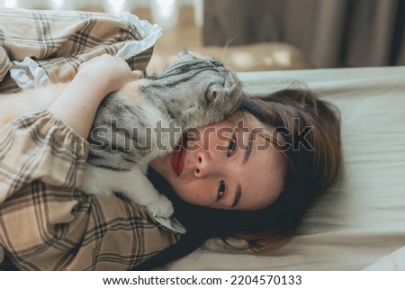 Happy asian  smile women hugging cute cat at home.