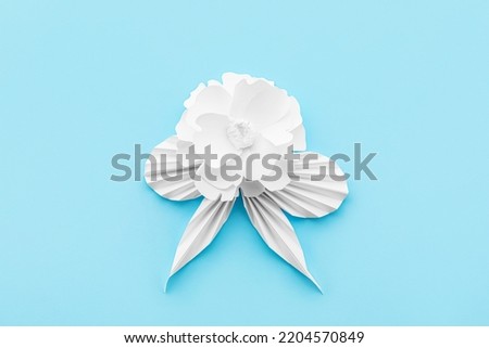 Paper flower with leaves on blue background