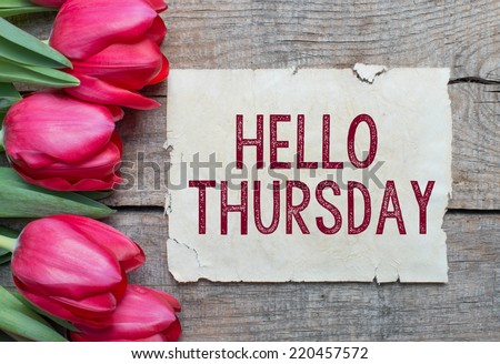 Tulips and paper with text Hello Thursday on wooden table Royalty-Free Stock Photo #220457572