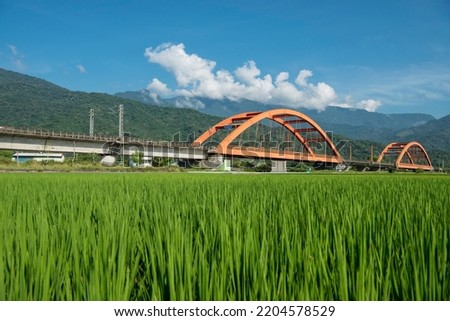 Train iron bridge over the paddy field background mountain Royalty-Free Stock Photo #2204578529