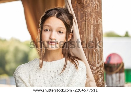 Close up portrait of a teenage girl in a white wool sweater