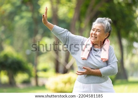 asian senior woman workout and practice tai chi in the park Royalty-Free Stock Photo #2204581185