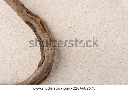 Natural cosmetic background for product presentation. Driftwood on the sand. Top view.