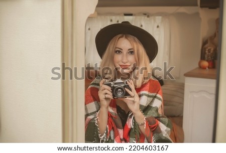  Young amateur photographer with an old camera takes pictures. Girl with a photo camera  have a good mood on a vacation