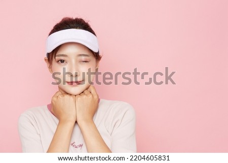 Portrait of young Asian woman in sporty fashion on pink background Royalty-Free Stock Photo #2204605831