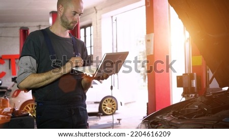 auto mechanic diagnoses a car using a computer. car workshop