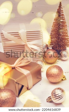   Christmas decorative composition with gold shiny snowflakes, christmas golden balls, gift boxes on rustic white wood background. Christmas or New Year concept. Festive Christmas background with baub