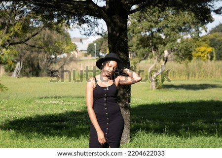 Young Attractive African Women holding her hat and her dress