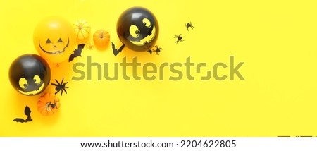 Composition with Halloween decor and balloons on yellow background with space for text, top view
