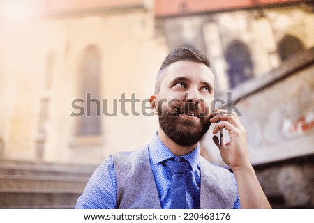 Handsome hipster modern businessman using smart phone in the city