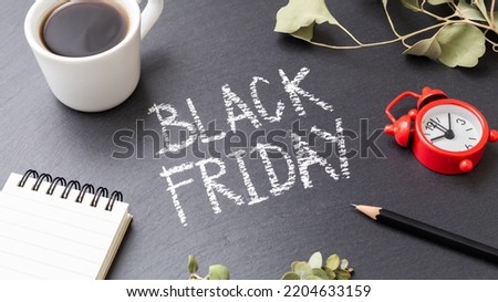 Black friday sale concept with coffee cup and stationery on black stone table