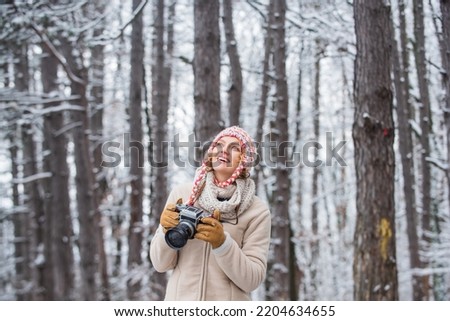 Winter hobby. Enjoy enchanting paleness and freezing atmosphere of winter. Taking stunning winter photos. Enjoy beauty of snow scenery through photos. Woman photographer with professional camera