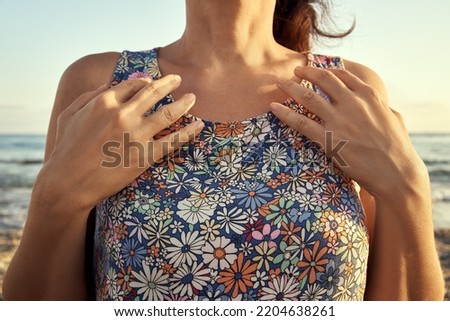 Woman at the sea side practicing EFT or emotional freedom technique - tapping on the collarboint point Royalty-Free Stock Photo #2204638261