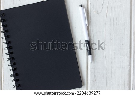 Note book with black pages with a pen